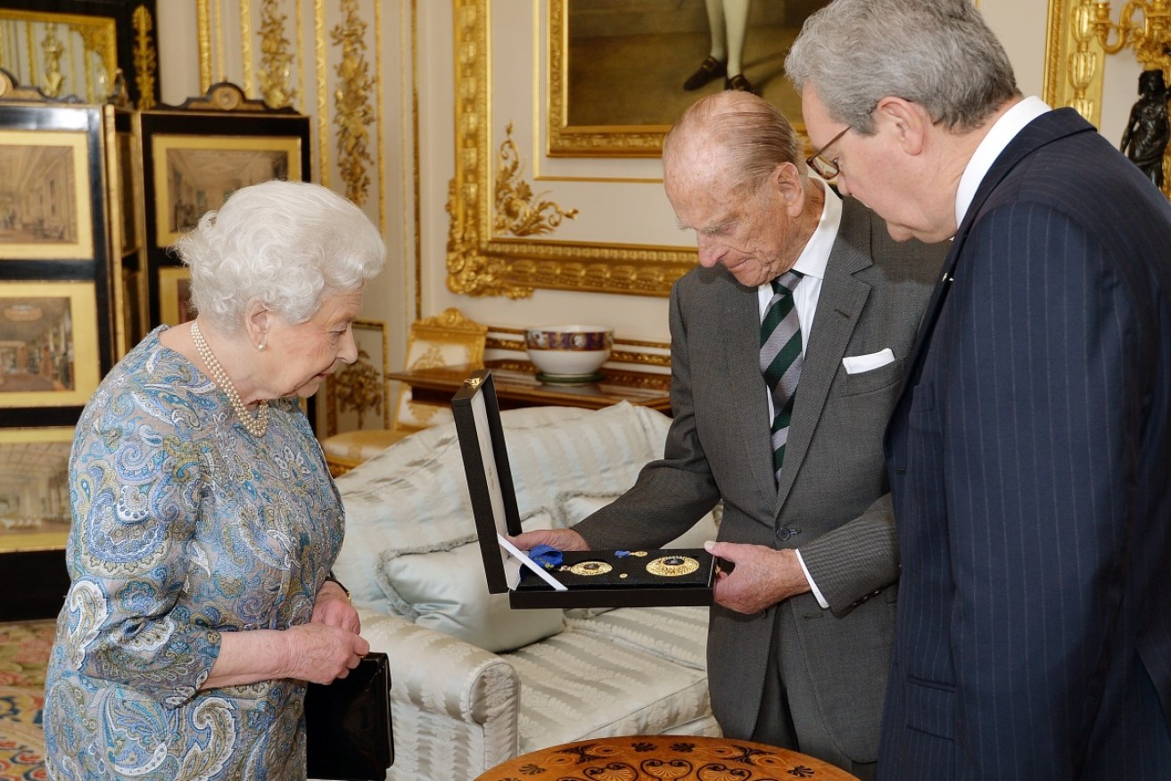 The Queen presents the Duke of Edinburgh with the Insignia of a Knight of the Order of Australia.