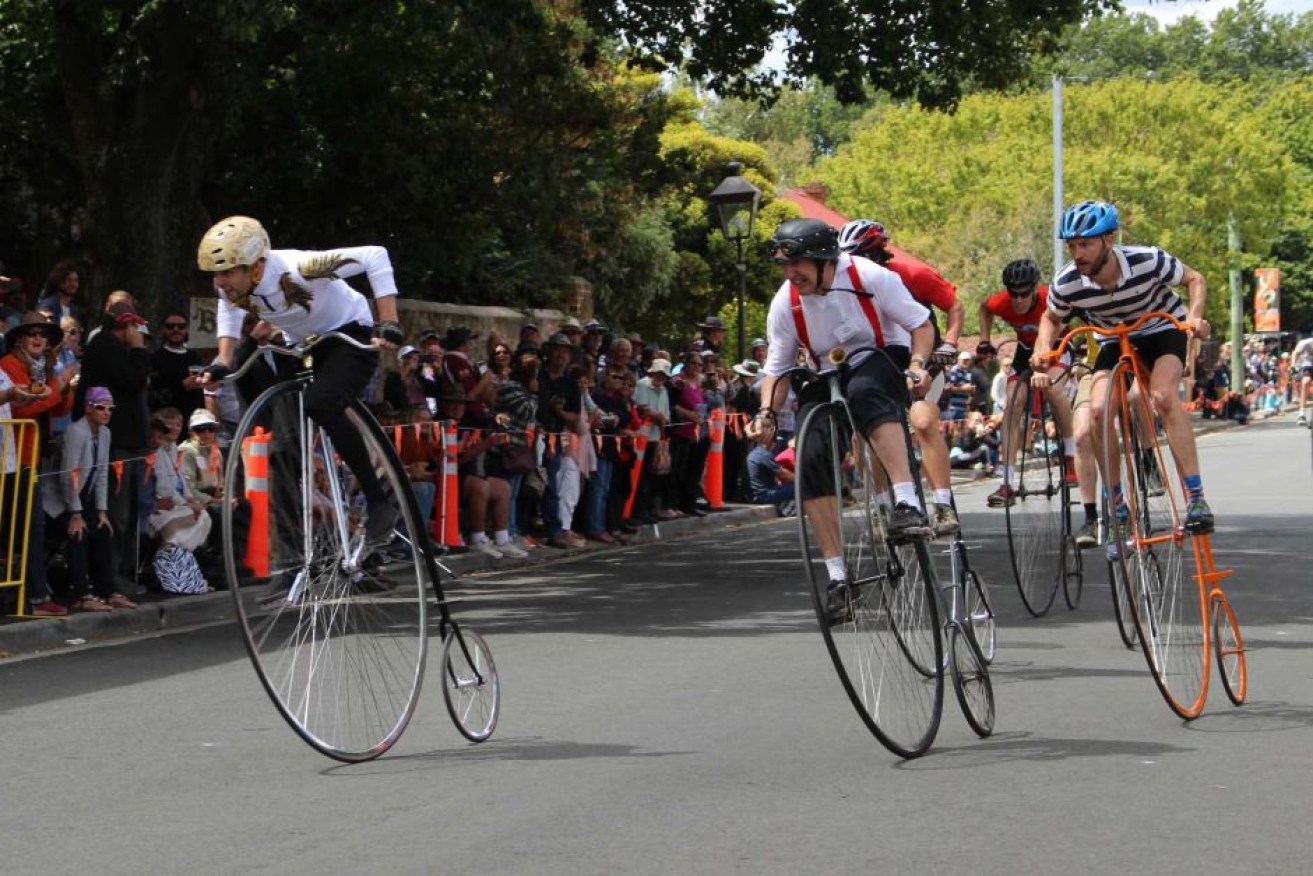 Darren Singline, left, on the way to winning the one-mile national penny-farthing championship.
