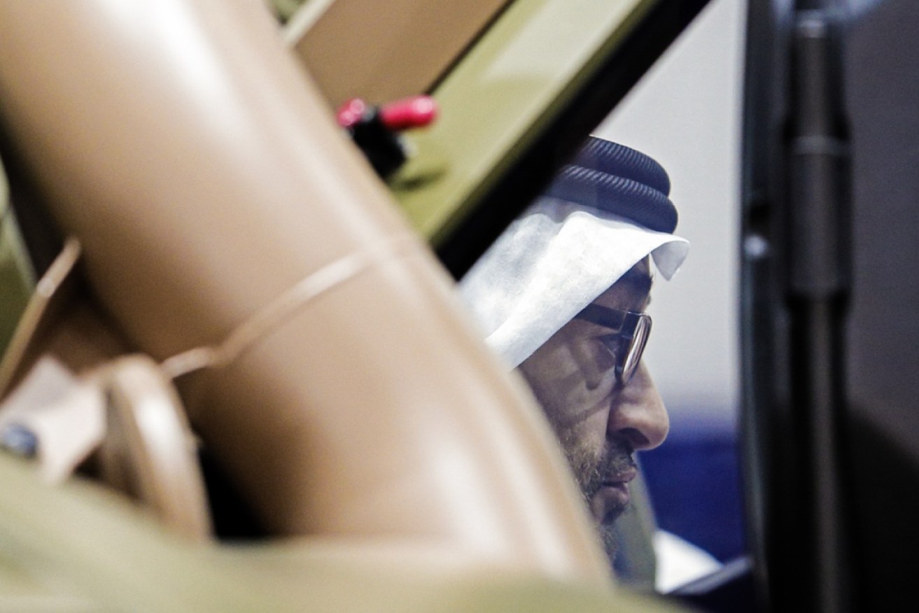 Crown Prince  Sheikh Mohammed standing behind a vehicle on show at the IDEX conference in Abu Dhabi. 