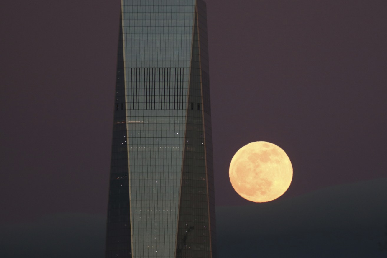 The Super Blood Wolf Moon rises behind One World Trade Center in New York City. 
