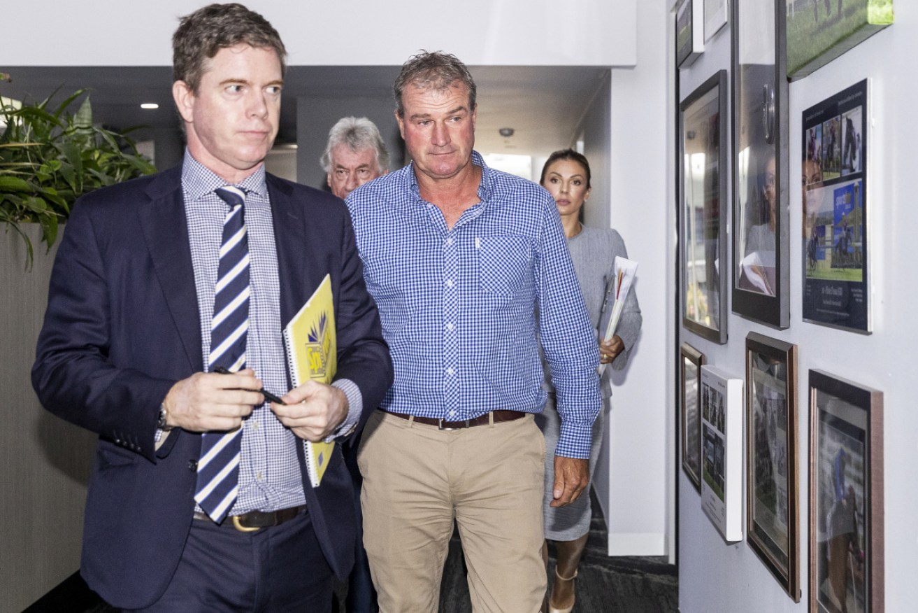 Darren Weir (right) leaves Racing Victoria's headquarters after being banned for four years.