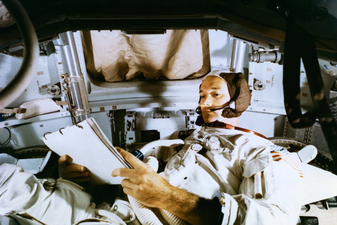 Michael Collins studies flight plans  during simulation training at the Kennedy Space Center in preparation for the moon landing mission.
