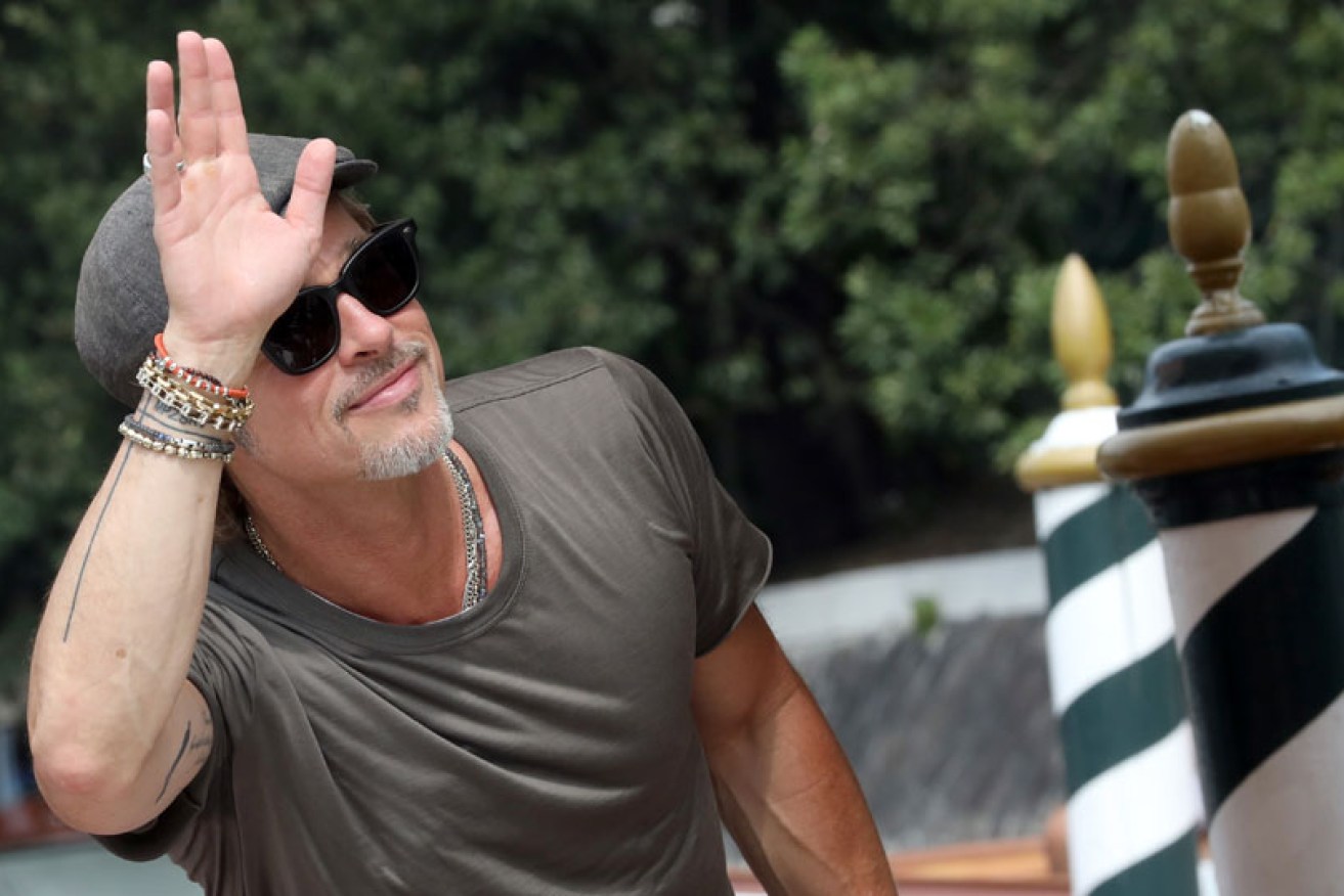 Hello to you, too: Brad Pitt waves at fans as he arrives in Italy on August 28 for the Venice Film Festival.