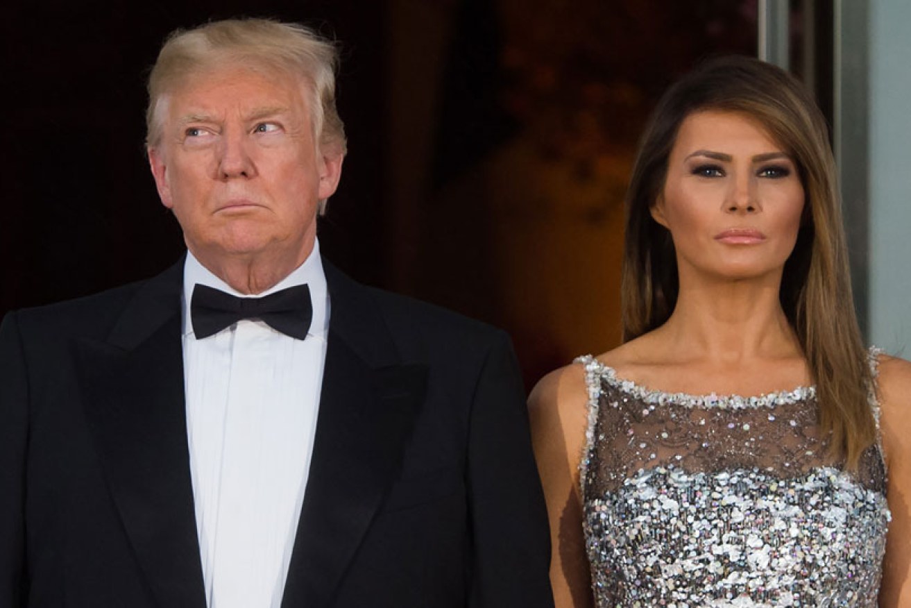 Donald and Melania Trump wait to greet Emmanuel and Brigitte Macron to a White House state dinner on April 24, 2018.