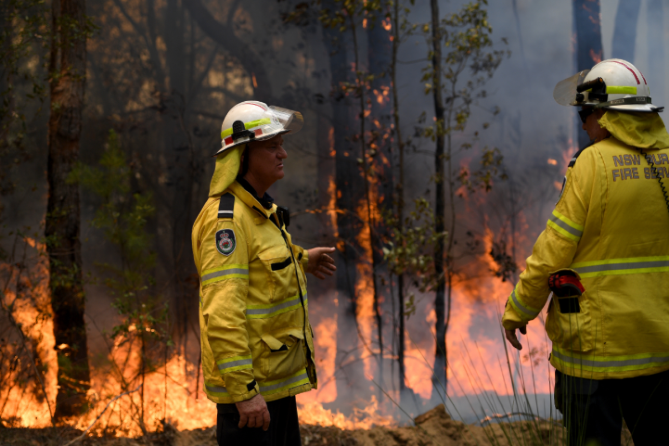 RFS firefighters keep a weather eye on their backburn intended to stop the raging main blaze.
