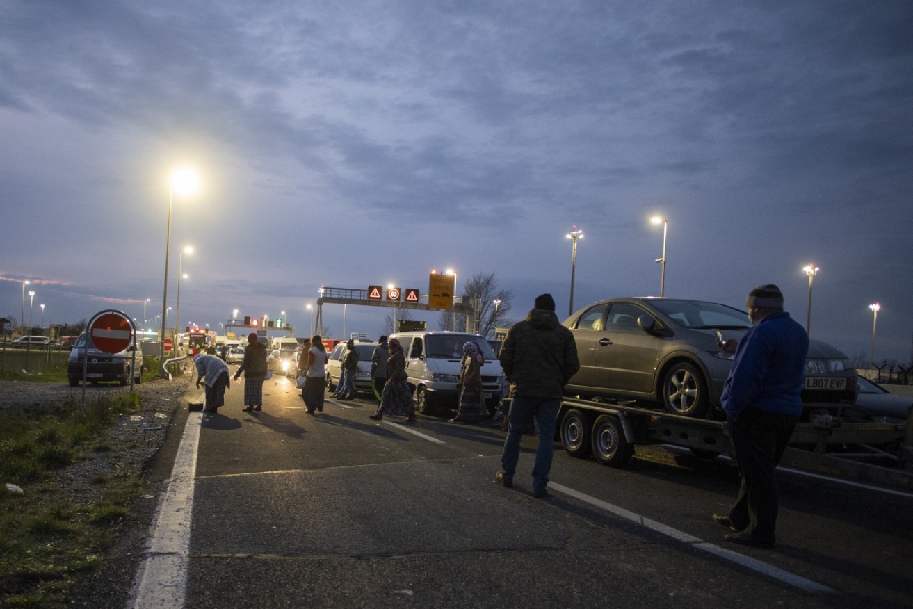 People gather outside their cars during a traffic jam towards the Austrian-Hungarian border after the EU travel ban was announced.