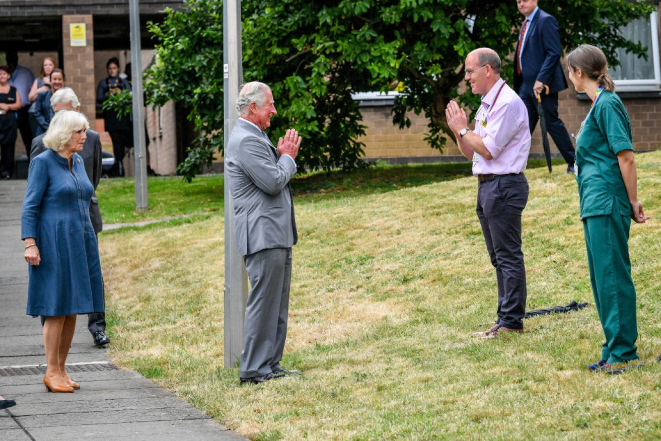 Prince Charles, Prince of Wales performs a namaste to Professor Mark Pietroni.