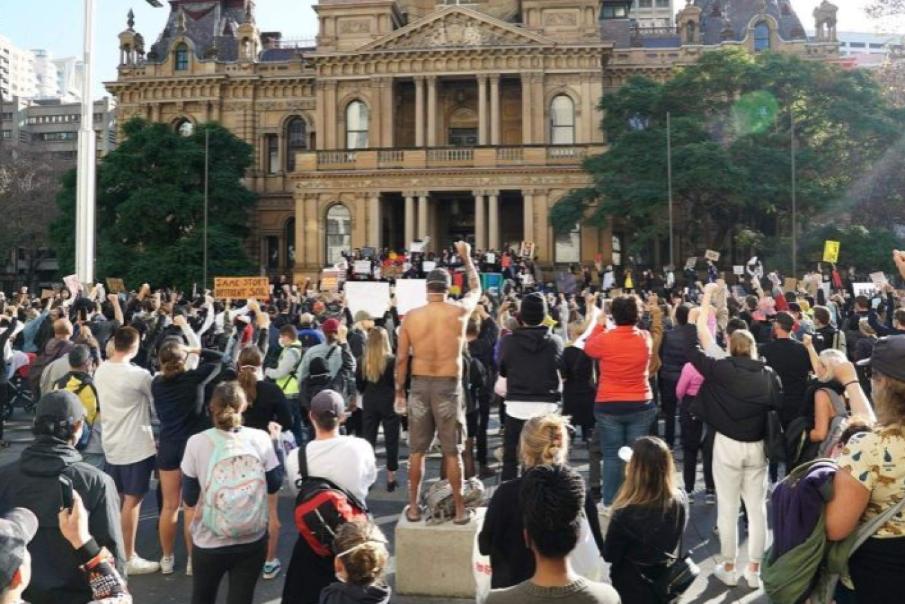 Protesters raise their fists in support of racial justice at the last Sydney BLM protest.