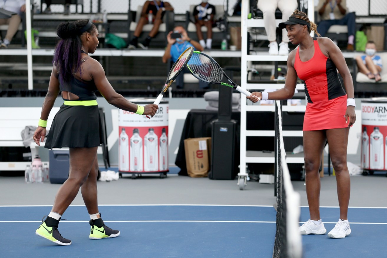 Serena Williams and Venus Williams touch rackets after their Top Seed Open encounter.