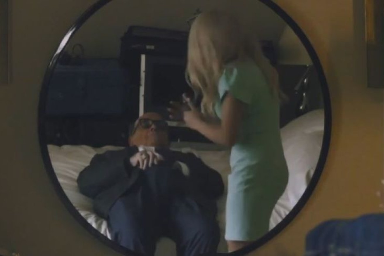 A scene from <i>Borat Subsequent Moviefilm</i>, showing Rudy Giuliani on a bed next to the actor Maria Bakalova.