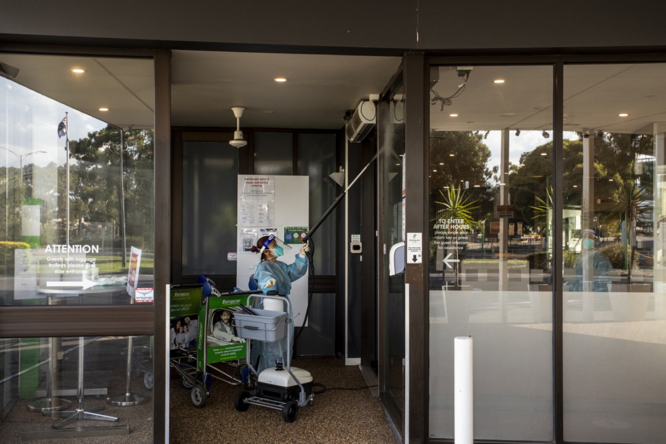 A cleaner at the Melbourne Airport Holiday Inn, which has been closed after a virus outbreak that has risen to 10 infections.