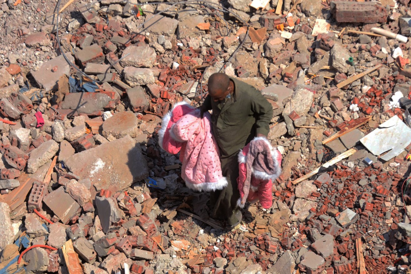 A man walks on the rubble of a collapsed nine-storey apartment building in the el-Salam neighbourhood of Cairo, Egypt.