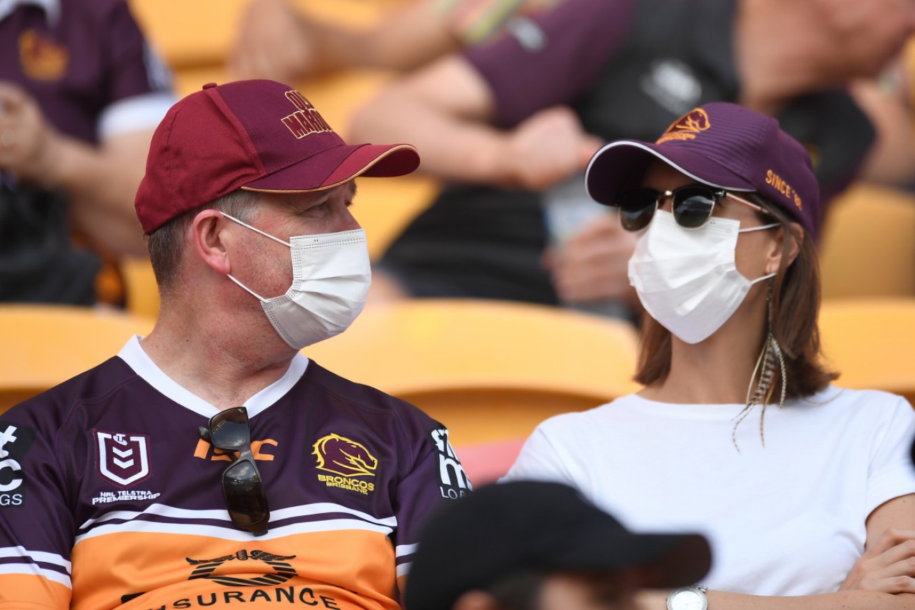 Broncos fans wear masks at Suncorp Stadium in Brisbane on Saturday.