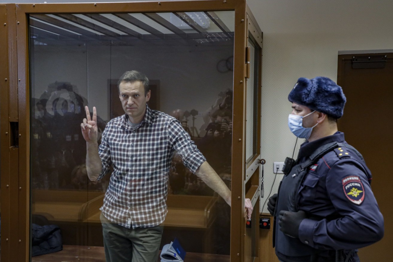 Russian opposition leader Alexei Navalny gestures inside a glass cage before a court hearing in Moscow on February 20.