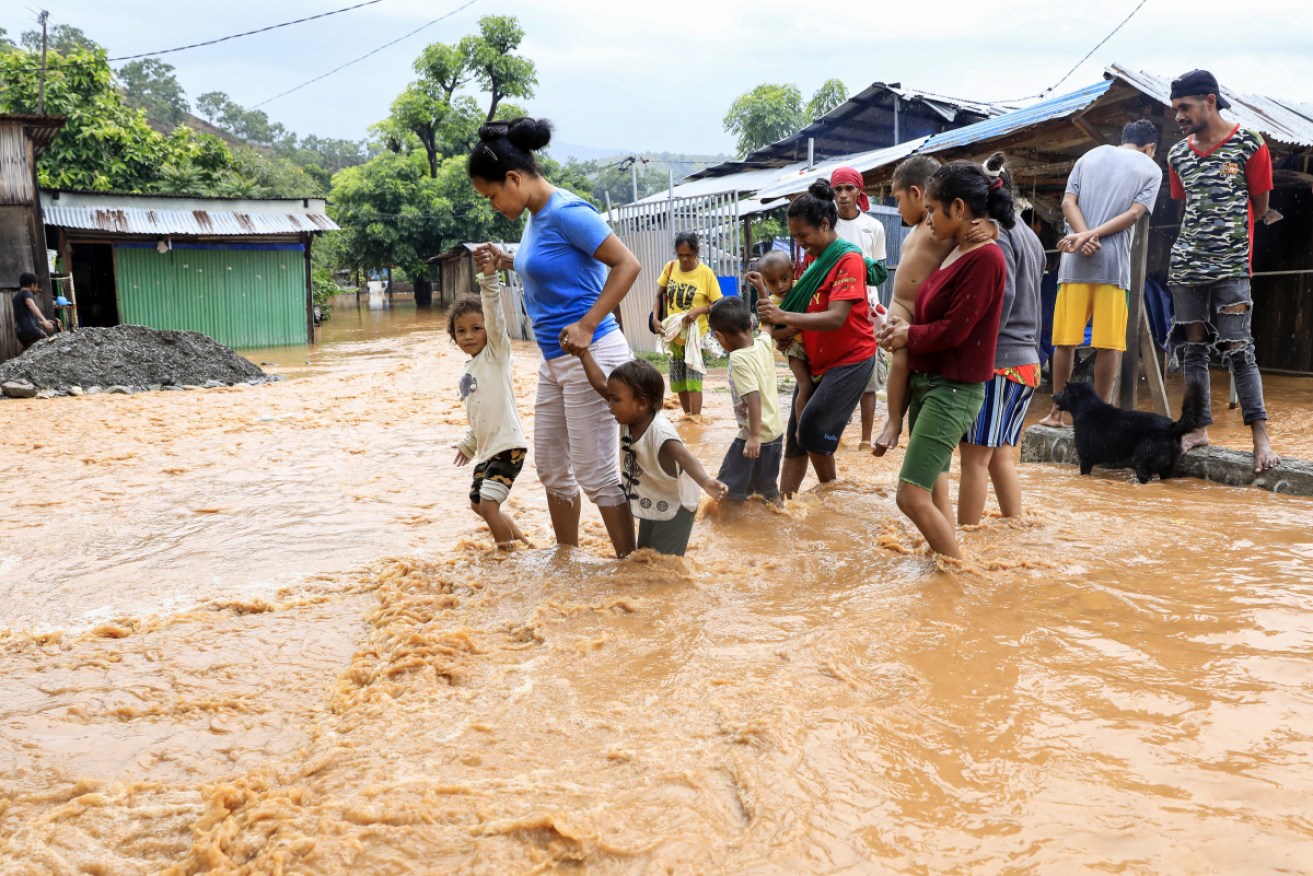Dili residents evacuate their flooded houses.