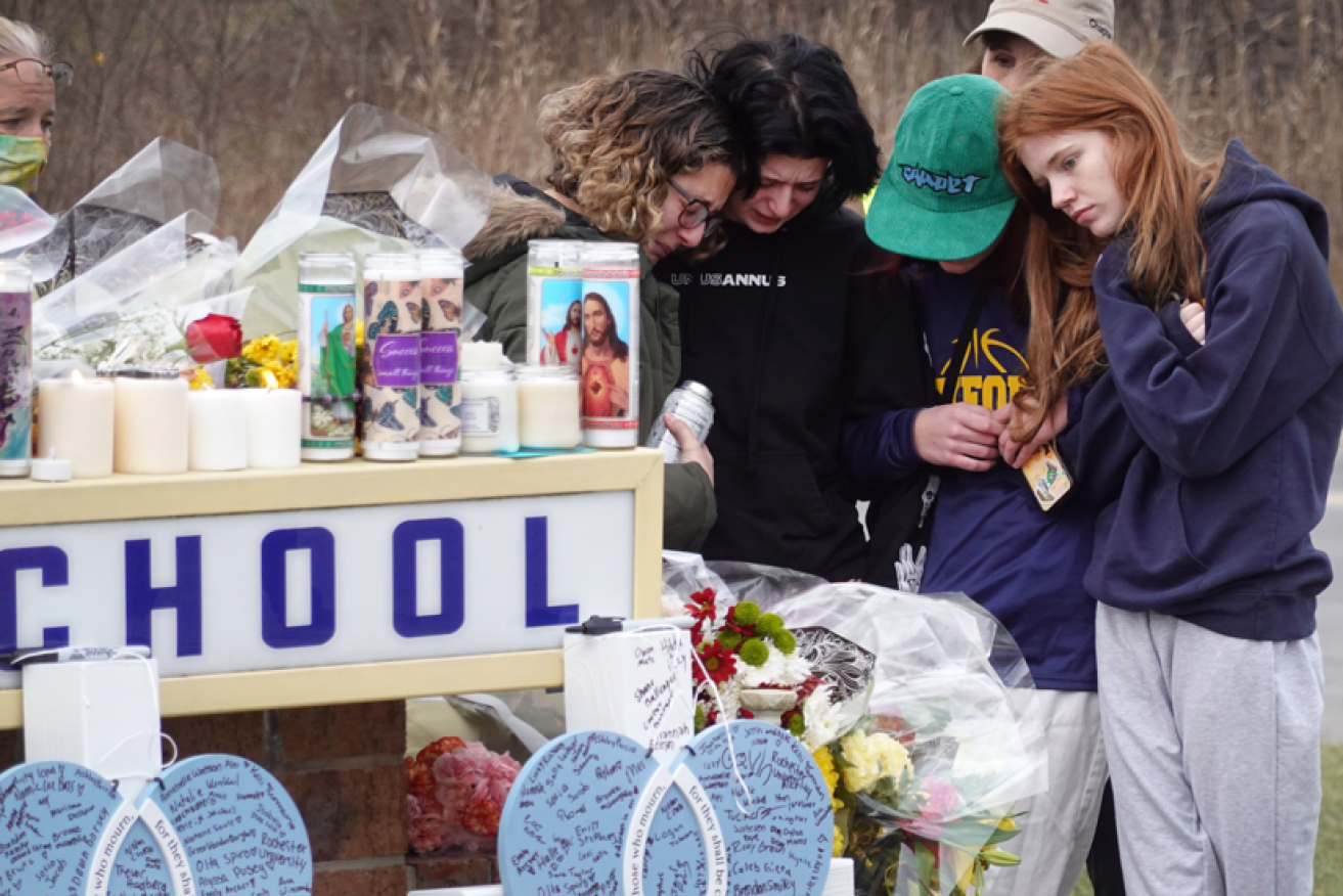 Distraught classmates of the four slain teens water a memorial with their tears.