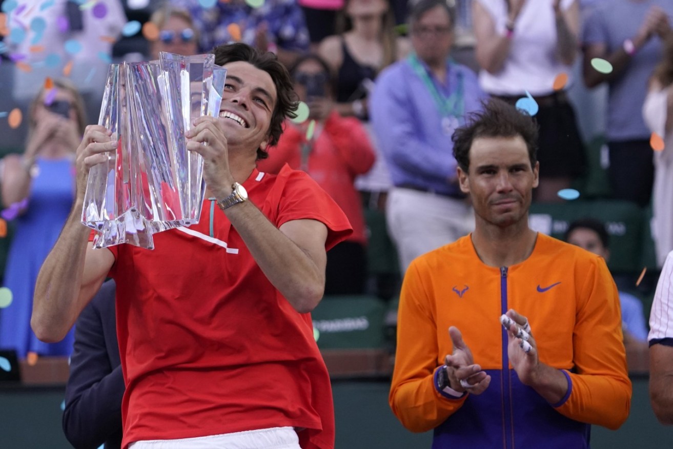 Taylor Fritz hoists the Indian Wells Masters trophy after defeating Rafael Nadal in the final.