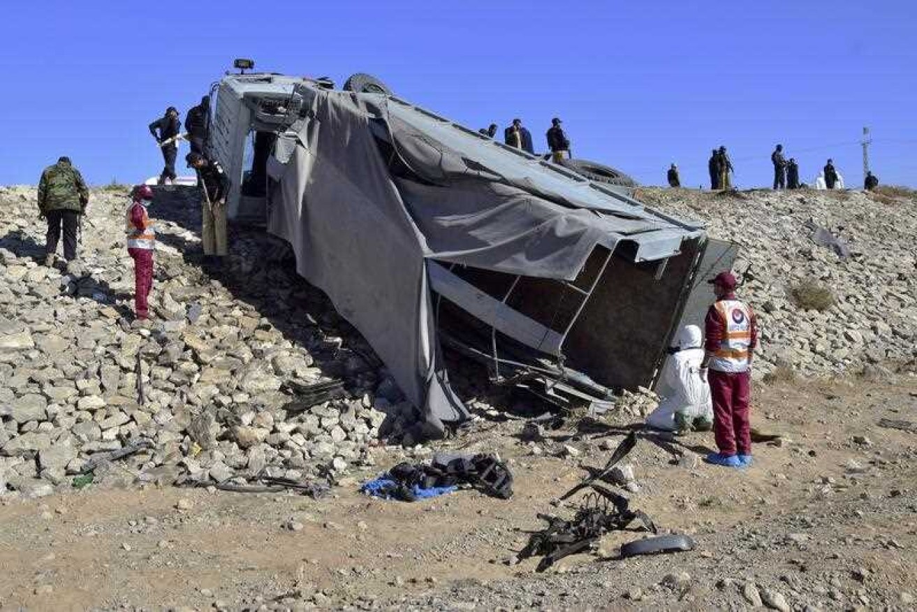 Pakistani security officials inspect a damaged truck at the site of suicide bombing on the outskirts of Quetta, Pakistan.