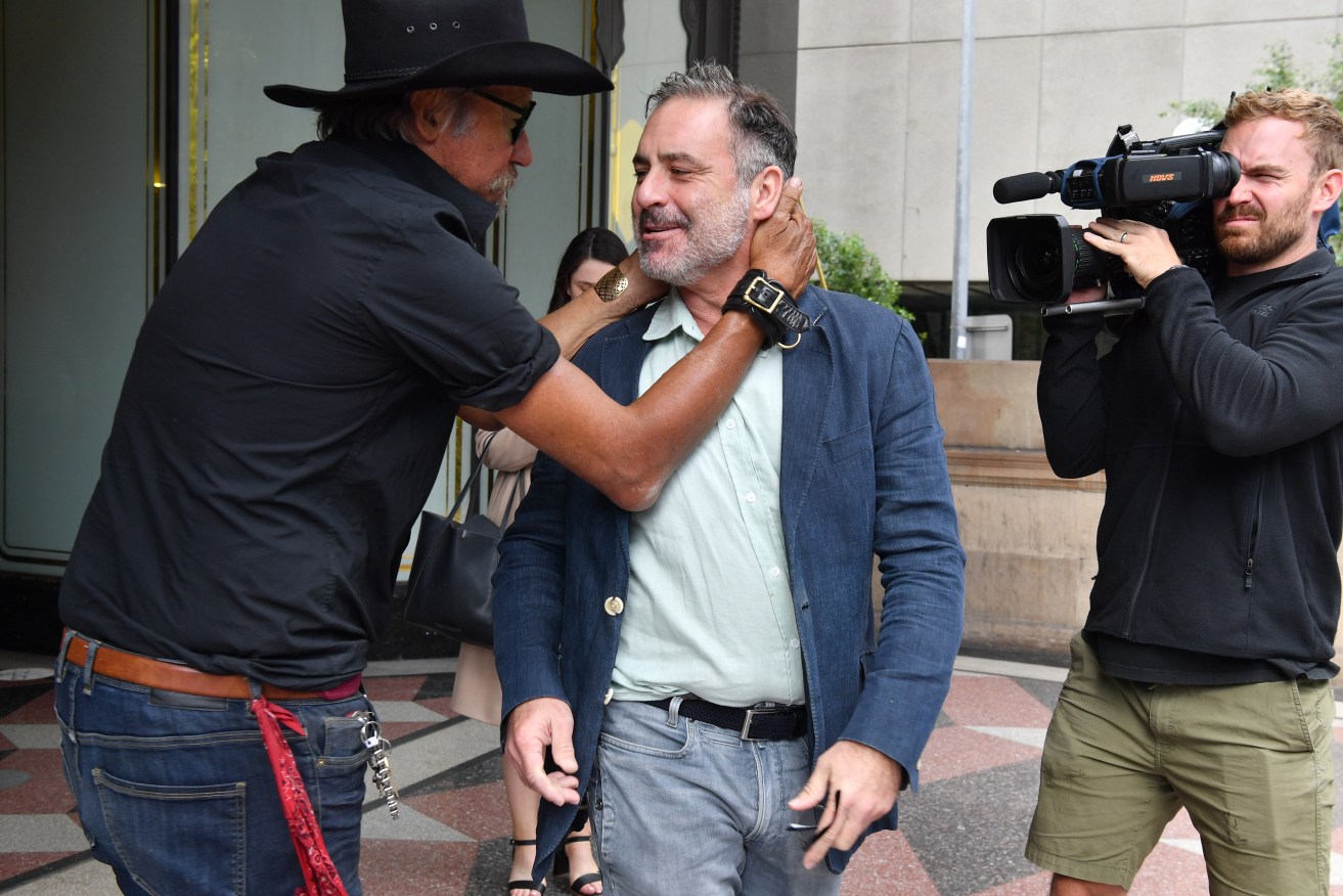 Andrew O'Keefe receives a random hug after emerging from a Sydney court.