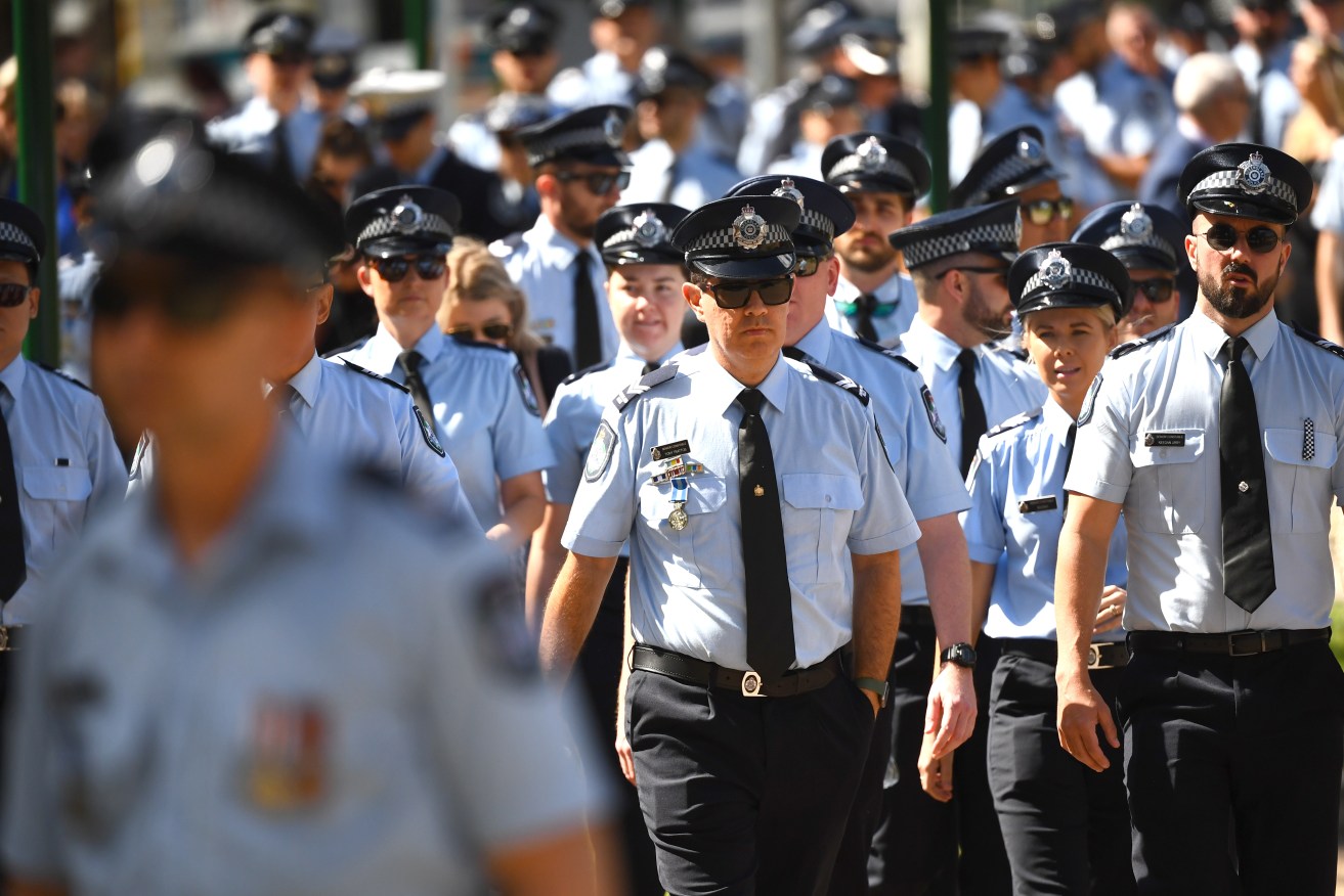Work goes on for thousands of Queensland police officers after a highly emotional ceremony for two young constables killed in the line of duty.