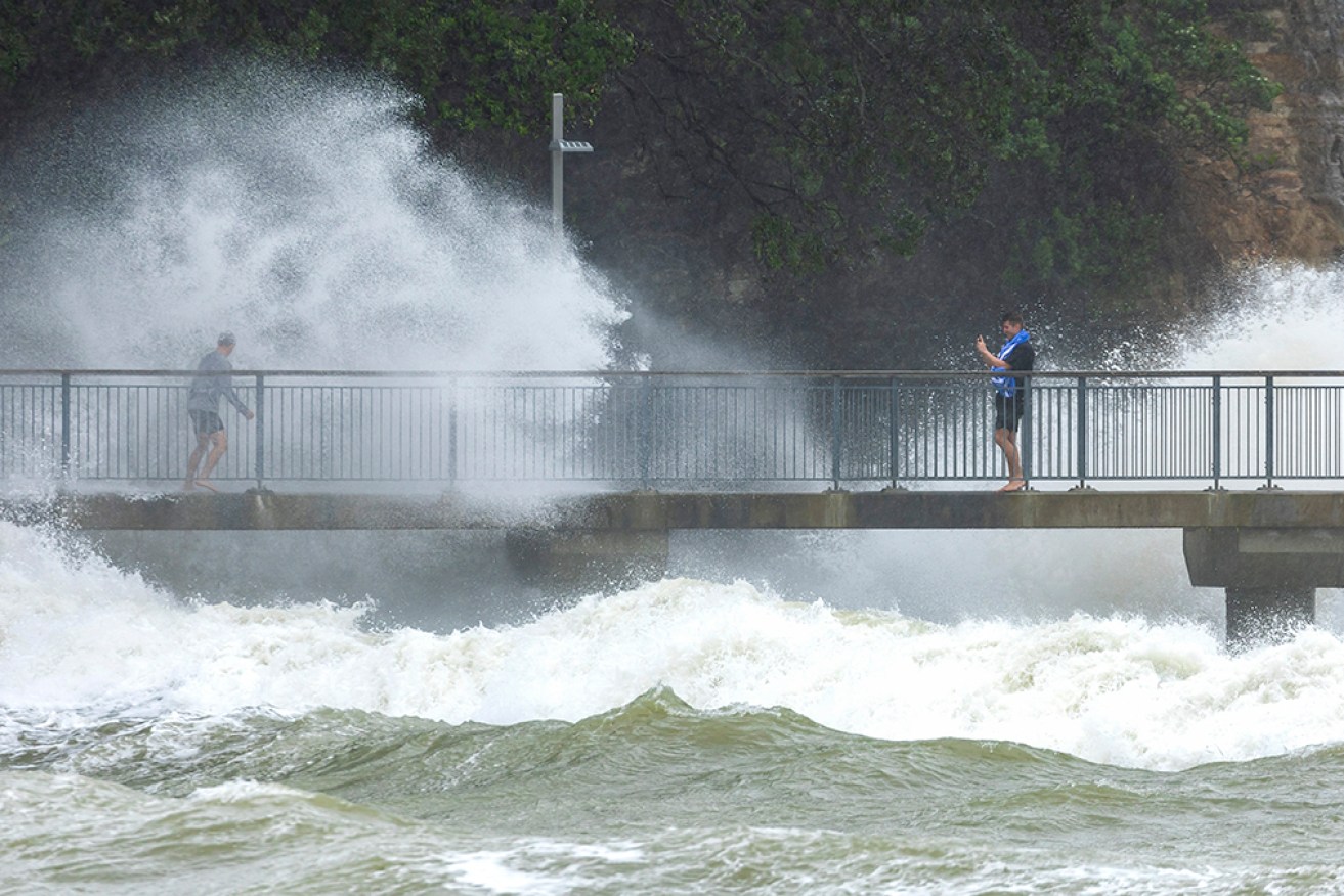 Waves crash against the cliffs at an Auckland beach as a cyclone hits the upper parts of New Zealand, on Sunday.
