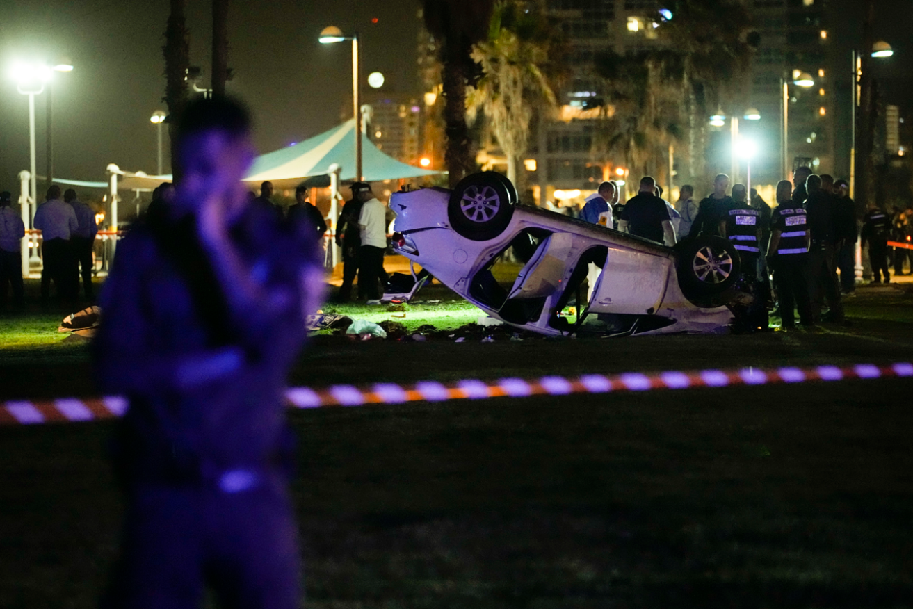 Police and anti-terror squad members surround what is left of the Tel Aviv attacker's crumpled vehicle. <i>Photo: AP</i>