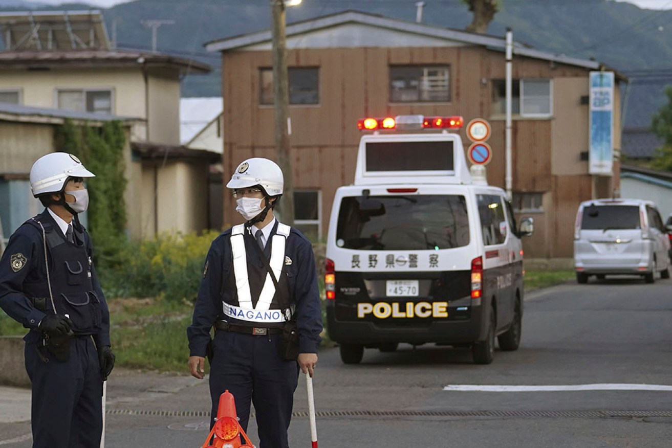 Police stake out a building where a man who killed three people is holed up in central Japan. 