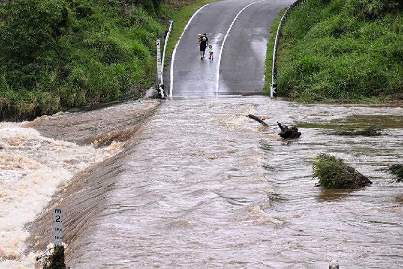A man has died as heavy rain brings widespread flooding across Queensland.