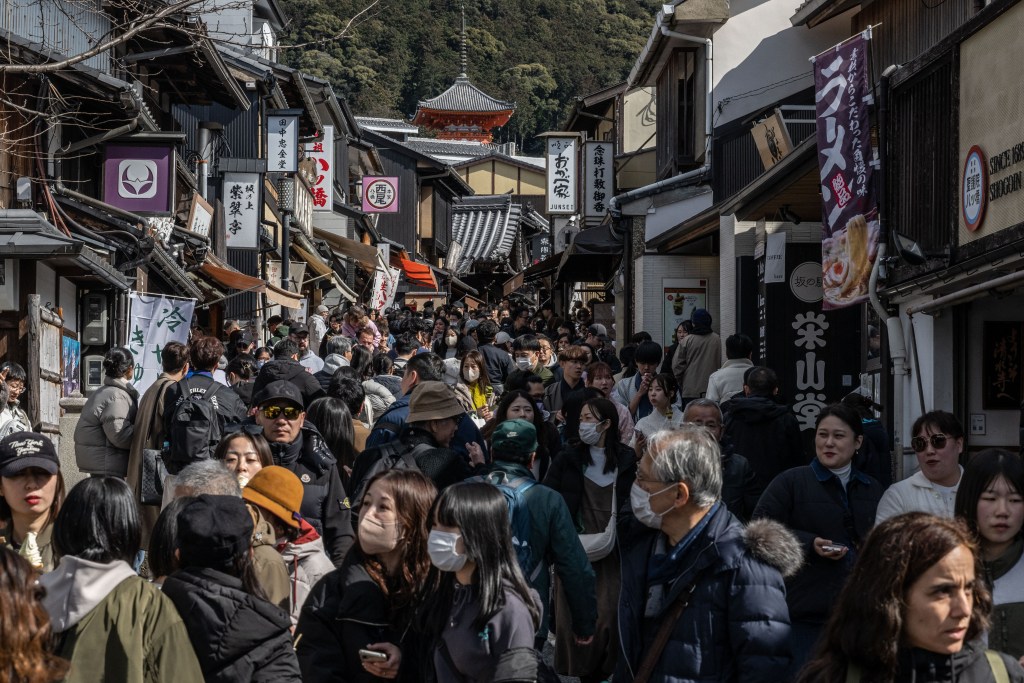 In this picture taken on March 10, 2024, people walk through a street near Kiyomizu-dera Temple in Kyoto.