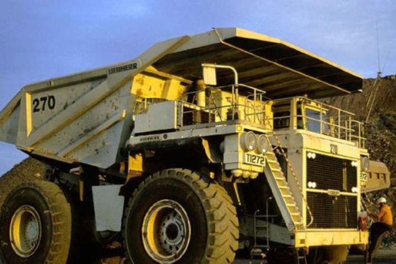 A mine worker climbs onto a mining truck at the Superpit in Kalgoorlie, Western Australia, December 2009.