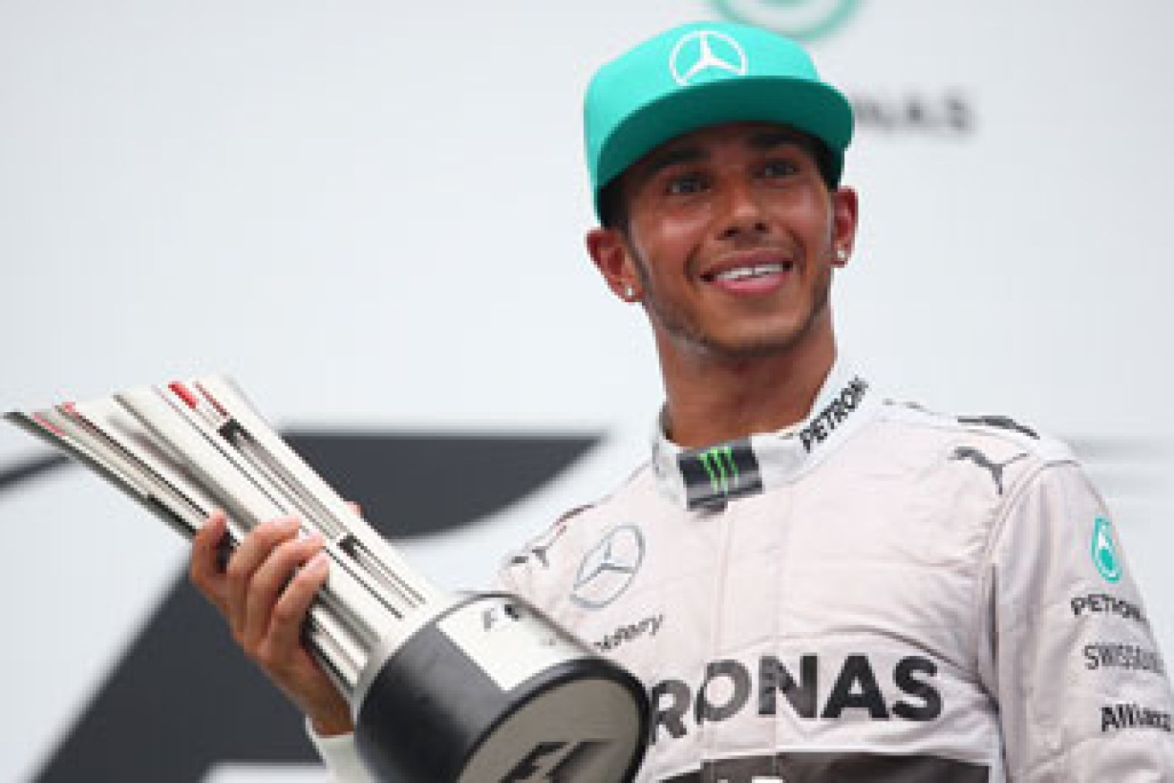 Lewis Hamilton with the spoils of victory. Photo: Getty