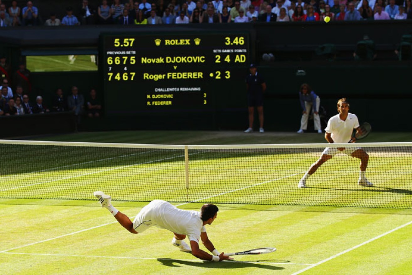 Djokovic dives to make a shot against Federer during their five-set epic. Photo: Getty