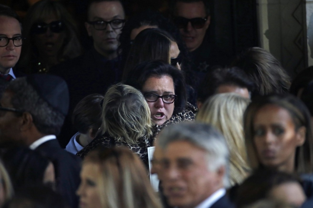 Comedian Rosie O'Donnell hugs a fellow mourner at the funeral.