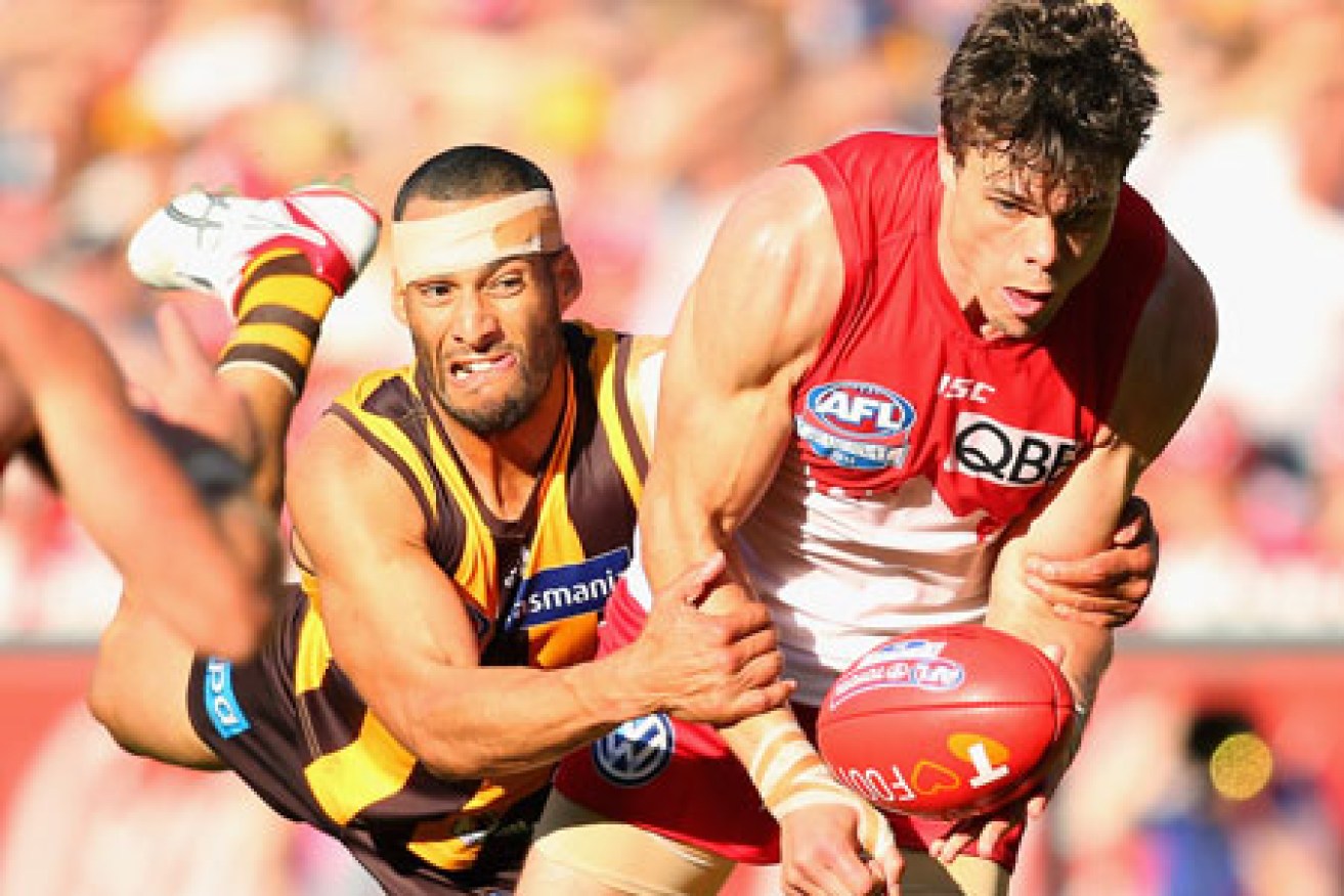 Josh Gibson epitomises Hawthorn's desperation in this tackle of Mike Pyke. Photo: Getty