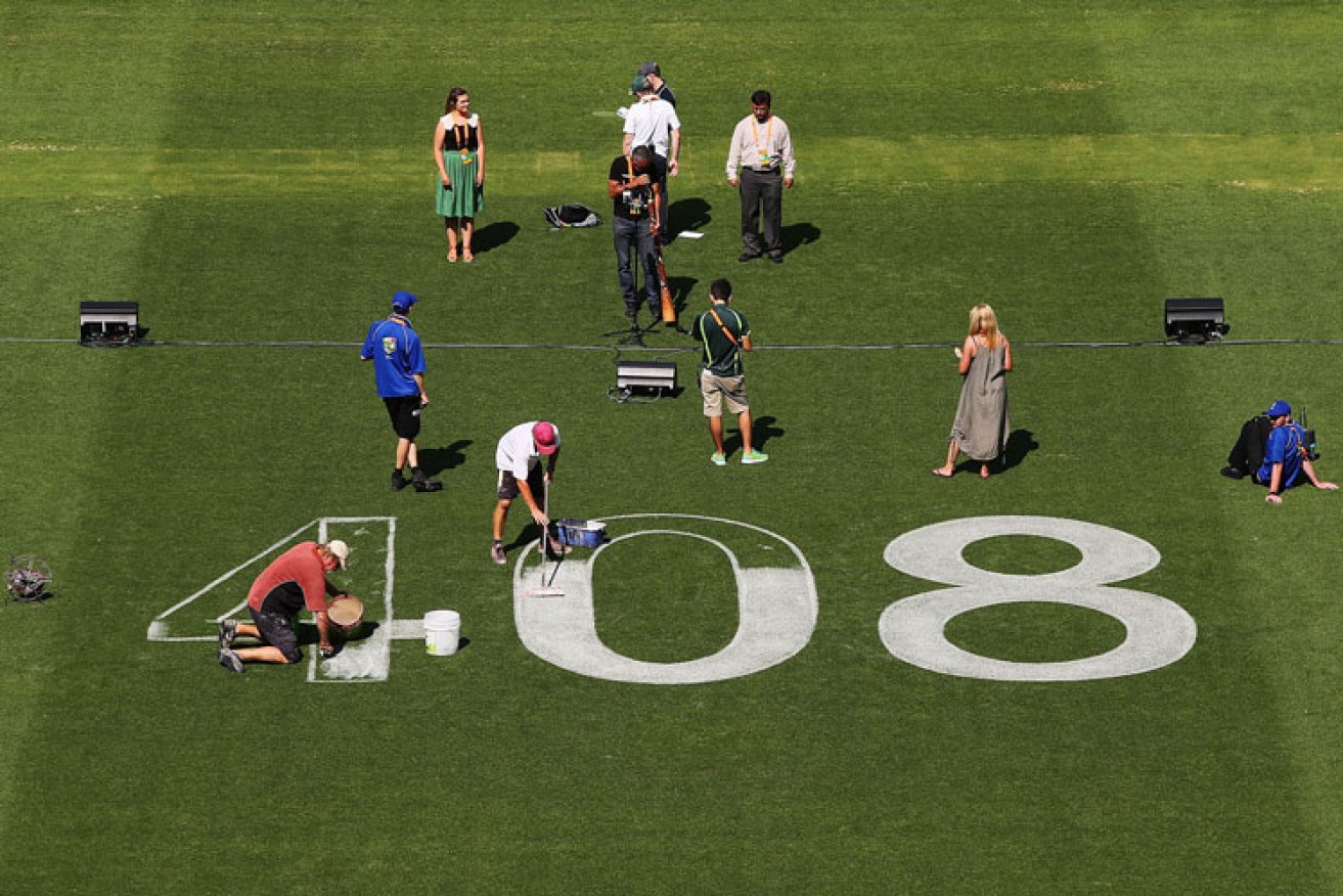 Ground staff prepare the Adelaide Oval, marking out Phillip Hughes' Test number on the turf. Photo: Getty 