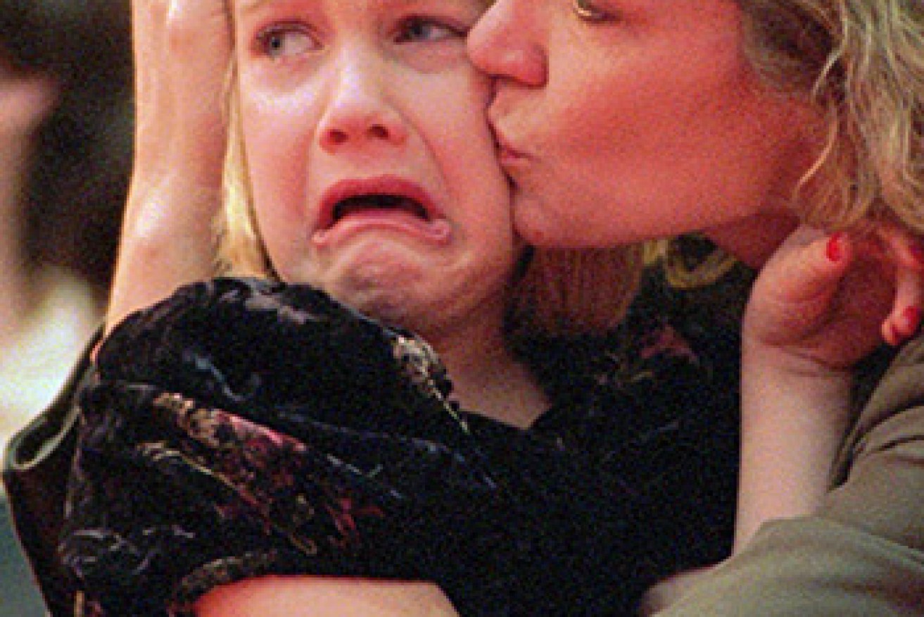 Nancy Schultz comforts her daughter Danielle, 6, at her husband Mark's memorial service in February 1996. Photo: AAP