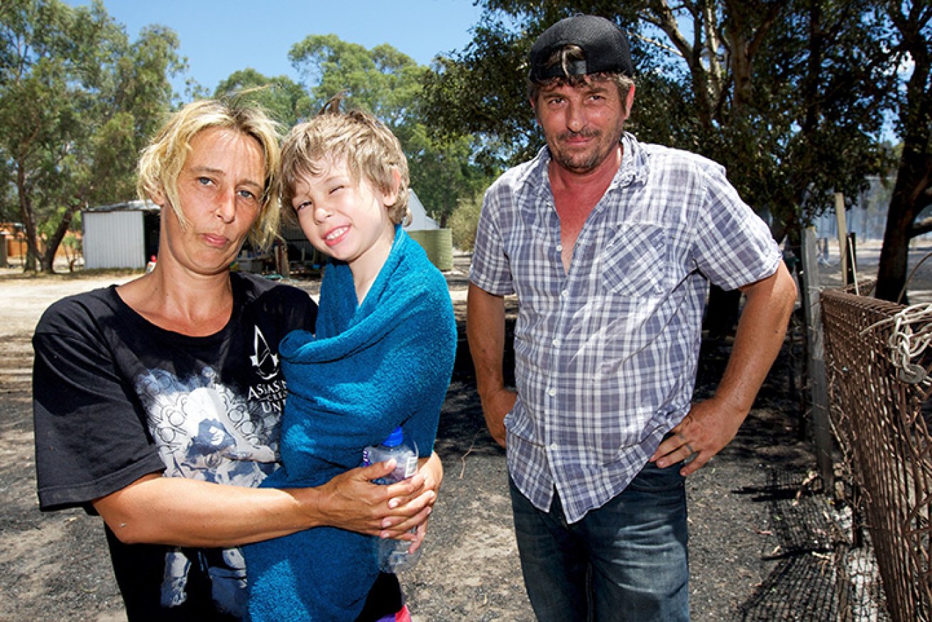 Rachael and Owen Barron next to their home which was saved by firefighters. Photo: AAP