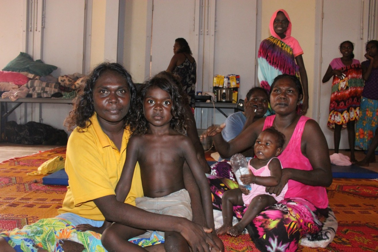 A family seek refuge at Shepherdson College cyclone shelter in Galiwinku, one of the worst hit communities. Photo: AAP
