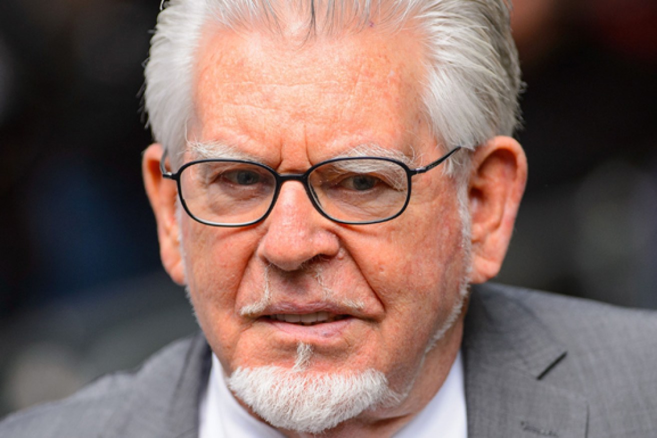 Rolf Harris is attending his trial by video link from prison.