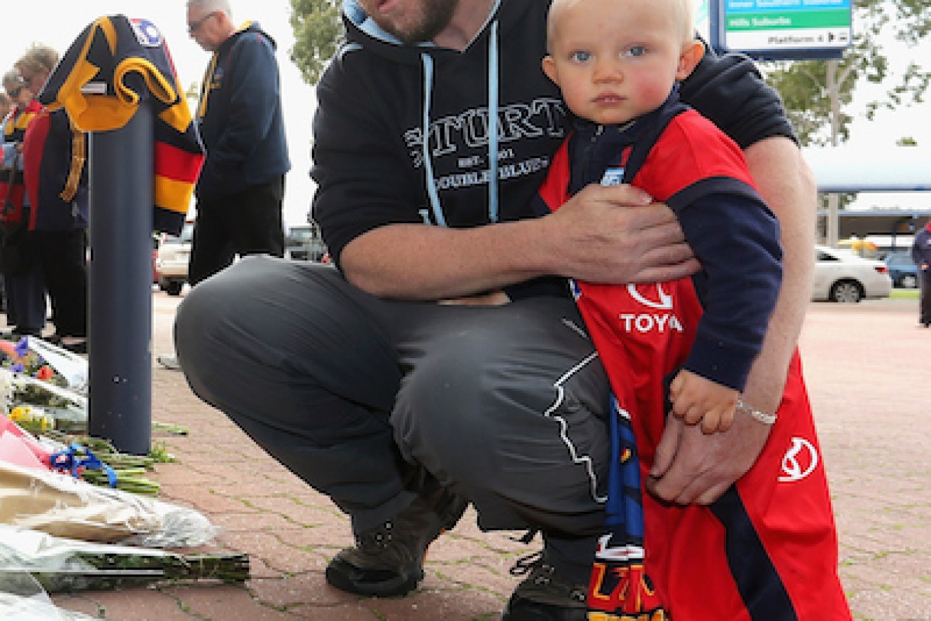 A tiny fan visits AAMI Stadium to mourn Walsh. Photo: Getty