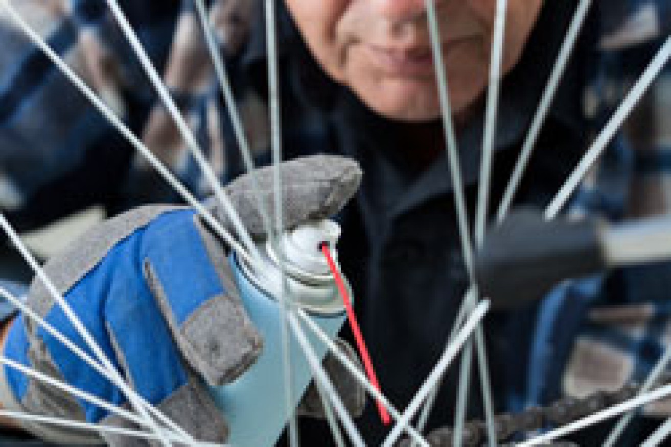 A man cleans his bike. Photo: Shutterstock