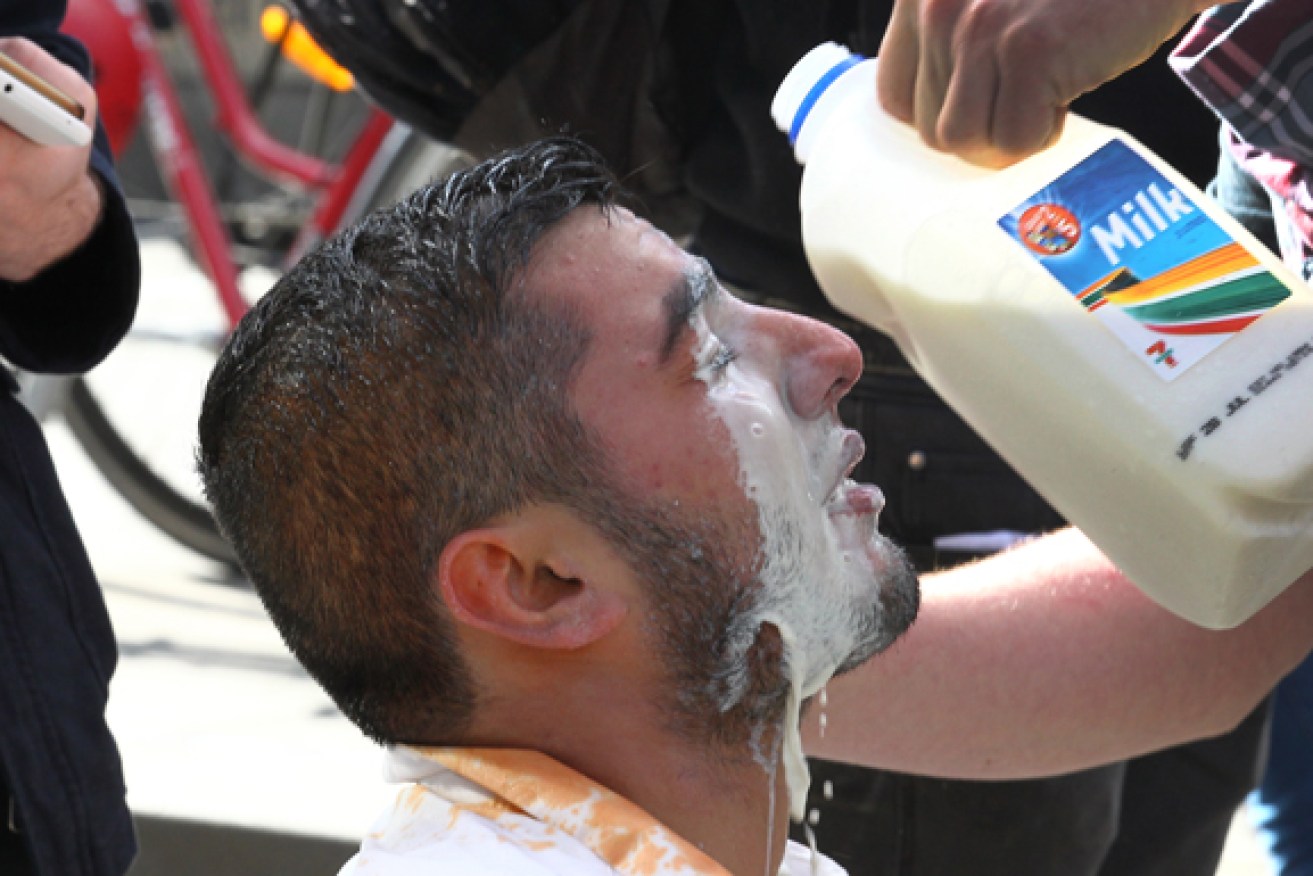 A protester gets his eyes washes out after being hit with police pepper spray during a protest in Melbourne.
