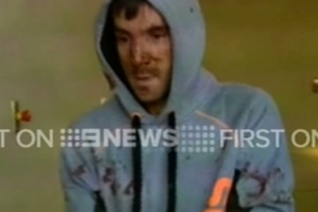 Mark Stocco pictured with a muddied face in police custody following arrest. Photo: 9 News