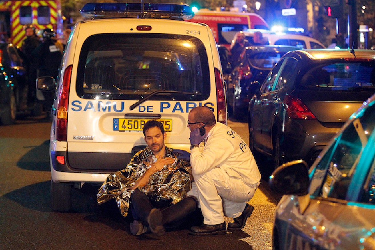 A medic tends to a man after an attack near the Boulevard des Filles-du-Calvaire. Photo: Getty