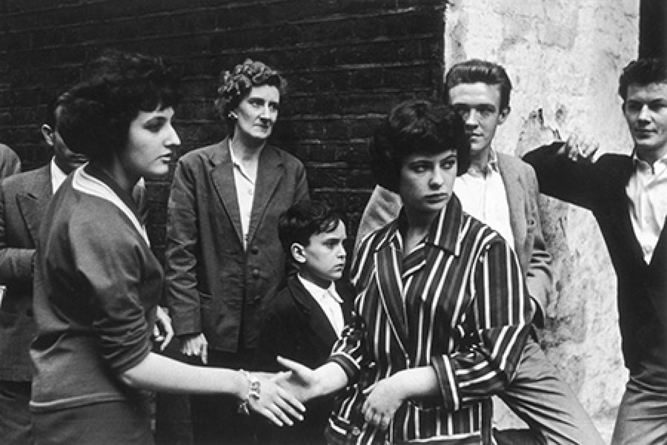 Soho teenagers in typical late  1950s attire of suits, striped  jackets and pullovers meet and  greet each other on the street       Date: 1959