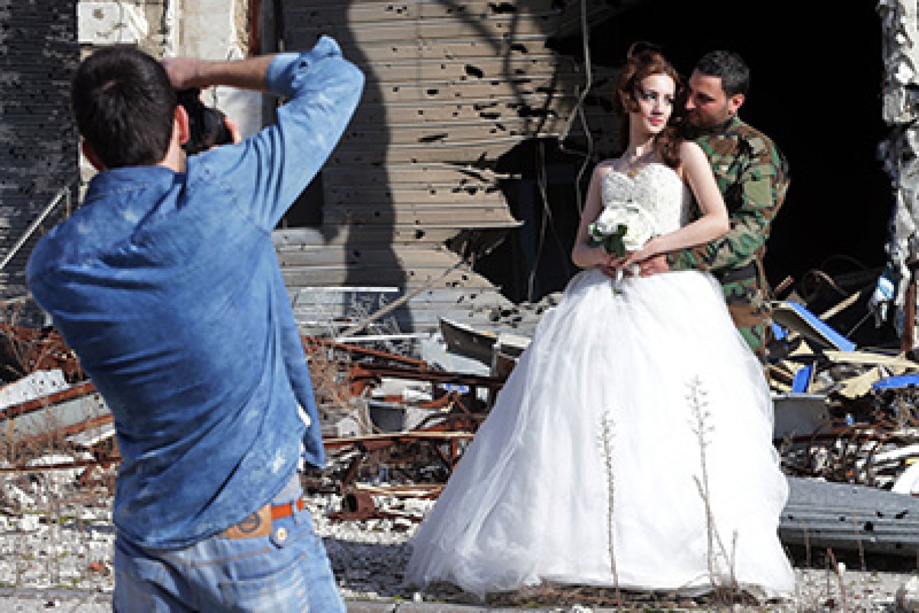 Newly-wed Syrian couple Nada Merhi,18, and Hassan Youssef,27, have their wedding pictures taken in front of a heavily damaged building in the war ravaged city of Homs on February 5, 2016.
A Syrian photographer thought of using the destruction of Homs to take pictures of newly wed couples to show that life is stronger than death.   / AFP / JOSEPH EID        (Photo credit should read JOSEPH EID/AFP/Getty Images)