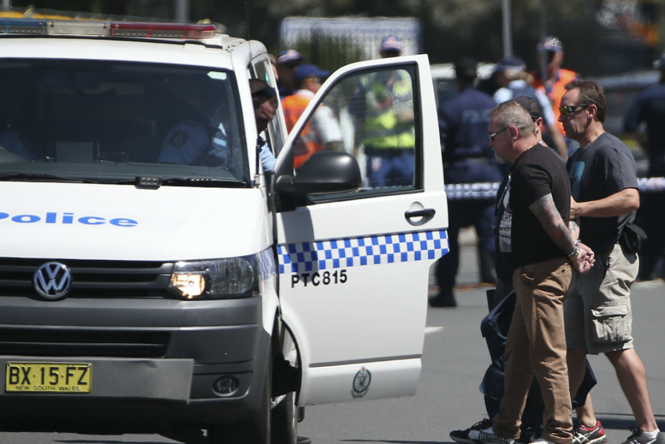 A man is led away from the scene by officers. He allegedly hindered police.Photo: AAP