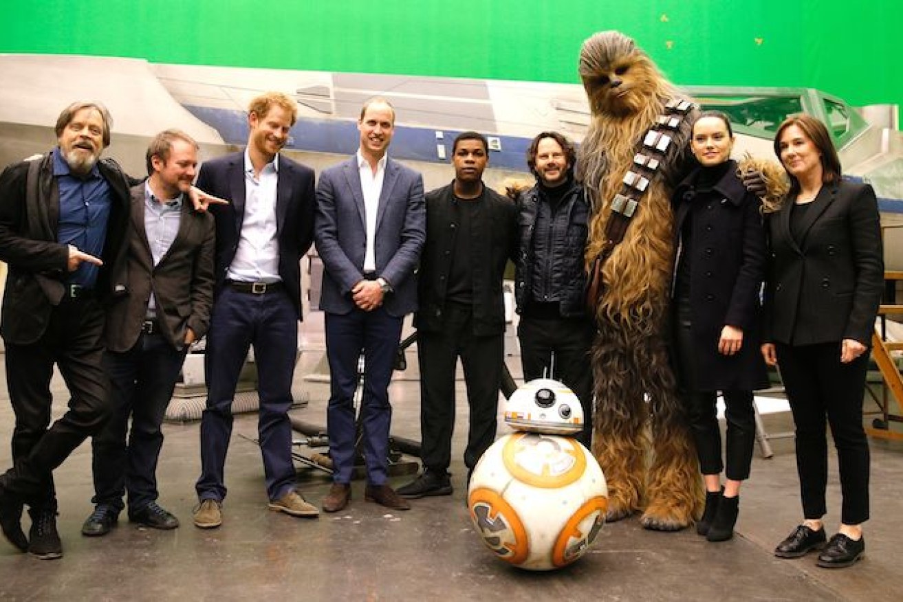 (L-R) US actor Mark Hamill, US director Rian Johnson, Britain's Prince Harry, Britain's Prince William, Duke of Cambridge, British actor John Boyega, Chewbacca and British actress Daisy Ridley pose during a tour of the Star Wars sets at Pinewood studios in Iver Heath, west of London on April 19, 2016. Photo: Getty