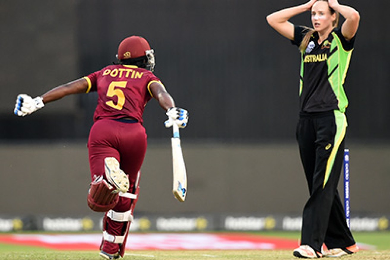 West Indies's Deandra Dottin celebrates after scoring the winning runs as Australia's Ellyse Perry reacts during the World T20 cricket tournament women's final match between Australia and West Indies at The Eden Gardens Cricket Stadium in Kolkata on April 3, 2016.   / AFP / INDRANIL MUKHERJEE        (Photo credit should read INDRANIL MUKHERJEE/AFP/Getty Images)