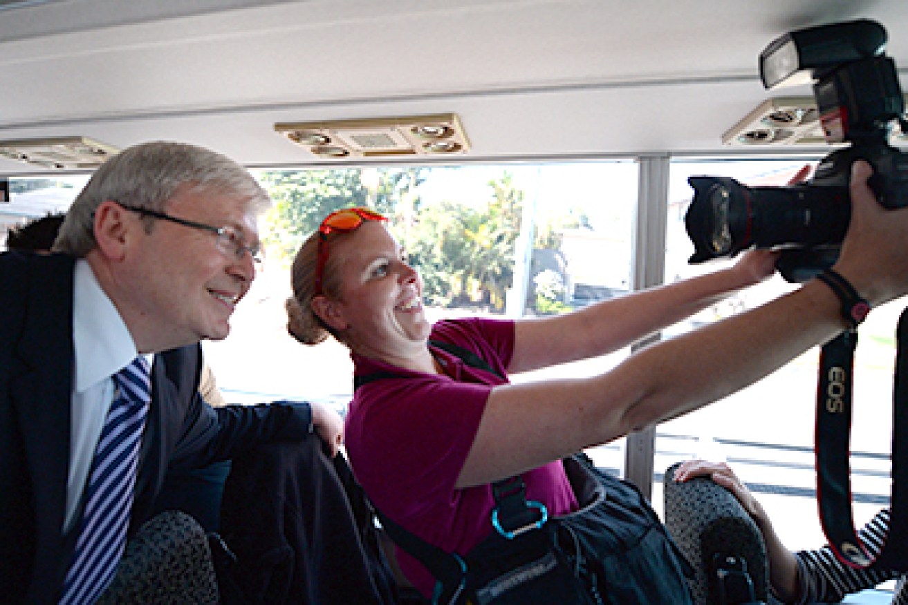 A photographer takes a picture of herself with Prime Minister Kevin Rudd while on the media bus in Brisbane, Tuesday, Aug. 6, 2013. The federal election will be held September 7. (AAP Image/Lukas Coch) NO ARCHIVING
